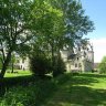 Le château de Fougères-sur-Bièvre vu du jardin. A gauche, bordé de végétation, le bief de la Bièvre creusé au début du XIXe siècle par  le baron Lambot de Fougères afin d'acheminer l'eau pour activer les métiers de la filature.